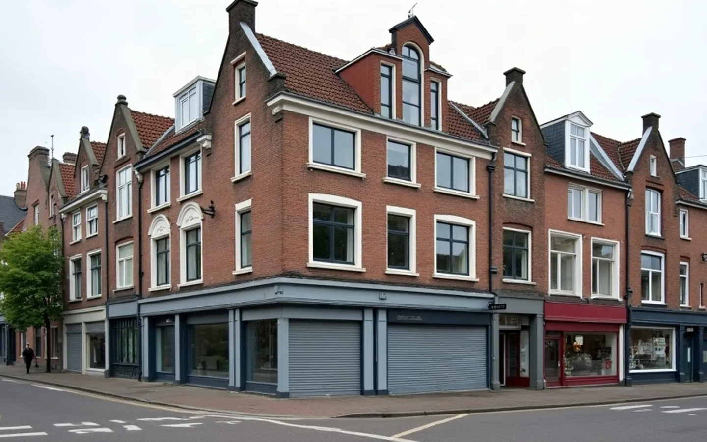 Hoekpand met winkelruimte op de begane grond en woonlagen erboven, aan een straat met meer van zulke panden.